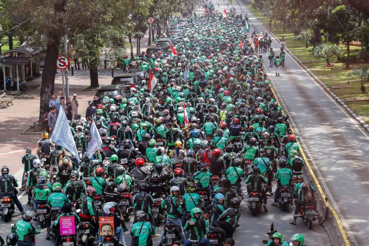 Pengemudi ojek online melakukan aksi unjuk rasa di depan Istana Negara, Jakarta Pusat, Selasa (27/3). Massa dari pengemudi ojek online menuntut pemerintah membantu untuk berdiskusi dengan perusahaan transportasi online agar merasionalkan tarif.