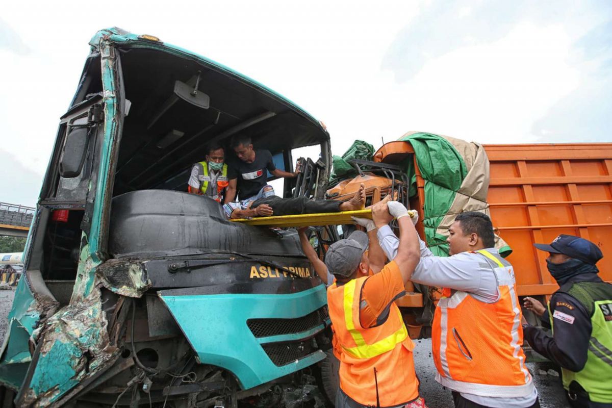 Petugas mengevakuasi supir bus Asli Prima saat terjadi kecelakaan di Gerbang Tol Cikupa, Tangerang, Banten, Minggu (13/01/2019). Bus Asli Prima yang melaju dari arah Jakarta keluar jalur menabrak truk yang melaju menuju Jakarta. Akibat kecelakaan ini dua orang luka berat dan belasan lainnya luka ringan.