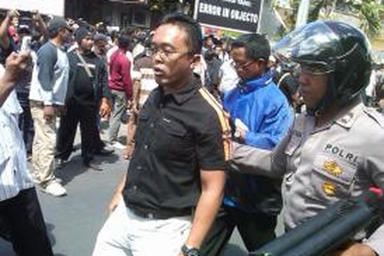 Polisi mengamankan pengacara pihak tergugat dalam eksekusi supermarket di Denpasar, Selasa (20/8/2013).