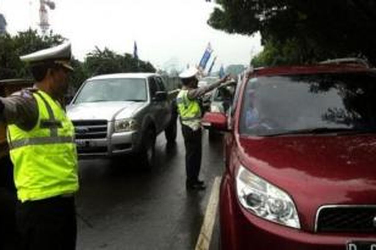 Polisi mengarahkan mobil yang hendak melintas di Jalan TB Simatupang untuk masuk jalan tol.