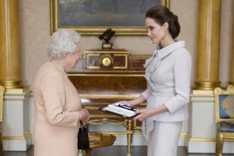 Aktris Angelina Jolie menerima penghargaan Dame dari Ratu Elizabeth II, di London, Inggris, Jumat (10/10/2014), untuk aktivitasnya terkait kampanye anti-kekerasan seksual di zona perang dan pelayanan bagi Inggris.
