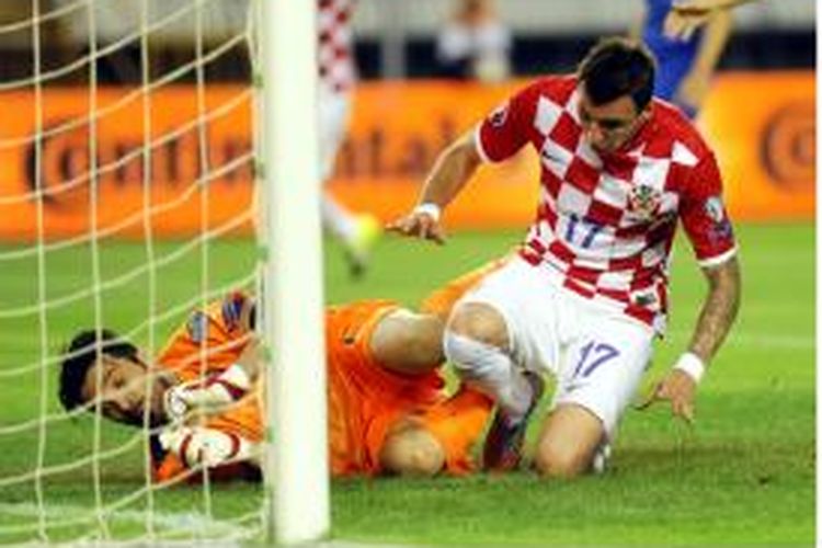 Penyerang Kroasia Mario Mandzukic (kanan) mencetak gol ke gawang Italia pada laga penyisihan Grup H kualifikasi Piala Eropa 2016 di Split, Jumat (12/6/2015). Mandzukic meluncur dan menghantam lutut kiper Italia Gianluigi Buffon.