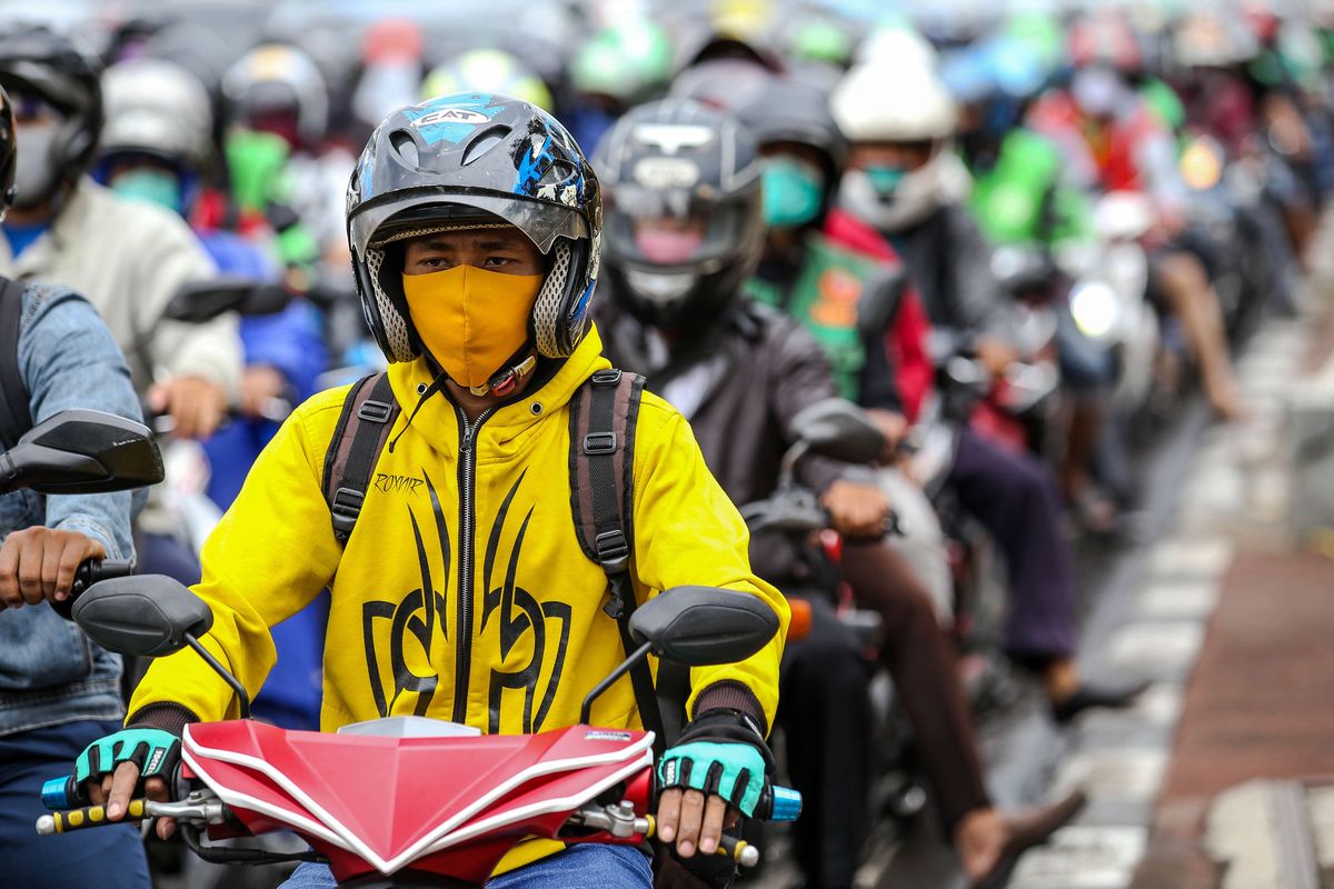 Warga menggunakan masker saat mengendarai sepeda motor di Jl. Letjen S. Parman, Jakarta Barat, Senin (4/5/2020). Provinsi DKI Jakarta memasuki pelaksanaan pembatasan sosial berskala besar (PSBB) yang diperpanjang ke tahap kedua. Tujuan PSBB ini adalah untuk menekan penyebaran virus corona (Covid-19).