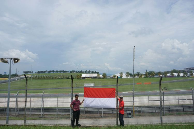 Pendukung Sean Gelael menempelkan bendera Merah Putih di pagar tribune K2 Sirkuit Sepang.