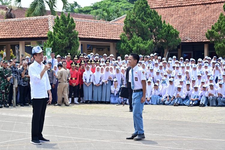 Presiden Joko Widodo saat mendapatkan pinjaman topi dari seorang siswa bernama Dika Rizki saat melakukan kunjungan ke SMK Negeri (SMKN) 1 Kedungwuni, Kabupaten Pekalongan, Jawa Tengah, Rabu (13/12/2023). 