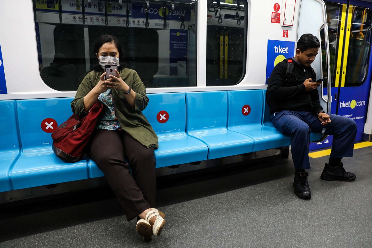 Warga duduk dengan menerapkan social distancing atau saling menjaga jarak guna mencegah penyebaran virus corona di Stasiun MRT Bundaran HI, Jakarta Pusat, Jumat (20/3/2020). PT MRT Jakarta (Perseroda) mengimbau para penumpang untuk menjaga jarak aman dengan penumpang lainnya, minimal dalam radius satu meter.