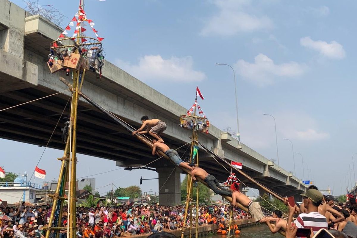 Kemeriahan lomba Panjat Pinang Emas yang diselenggarakan RW 04 Kelurahan Cipinang Melayu, Jakarta Timur, bekerja sama dengan BUMN Pegadaian dalam perayaan Hari Ulang Tahun (HUT) ke-78 Indonesia, Sabtu (19/8/2023). Hadiah utama dalam perlombaan ini yakni emas batangan.