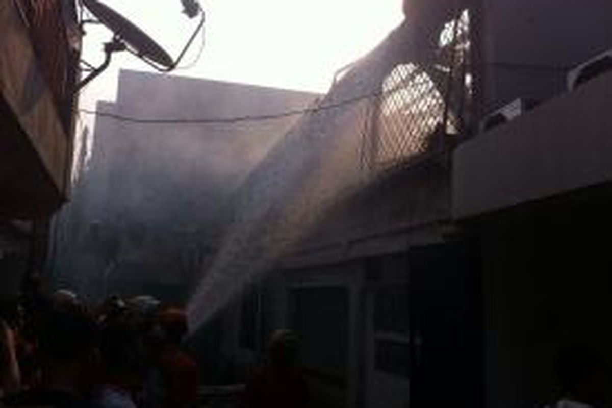 Petugas damkar berupaya menadamkan api di dalam rumah kos yang terletak di Gang Lilin kawasan Gunung Sahari, Jakarta Pusat Jumat (25/9/2015) sore.  