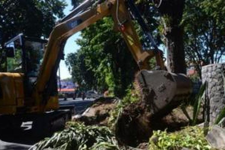 Alat berat dikerahkan untuk membenahi kondisi taman di sepanjang Jalan Darmo dan Taman Bungkul yang rusak akibat diinjak-injak ribuan warga, Minggu (10/5/2014). 
