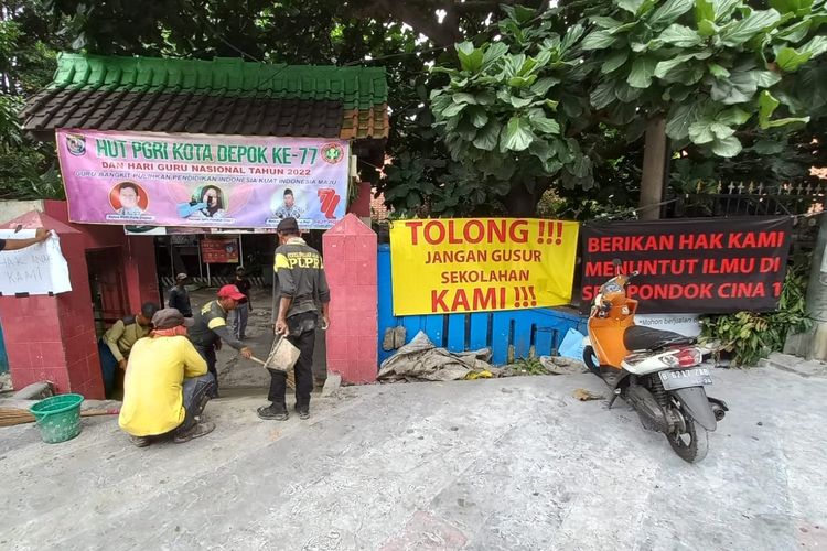 Dikeluhkan orangtua siswa lantaran revitalisasi trotoar Margonda lebih tinggi daripada permukaan sekolah, petugas Dinas PUPR Kota Depok tengah membuat akses jalan menuju SDN Pondok Cina 1, Beji, Depok pada Rabu (9/11/2022).