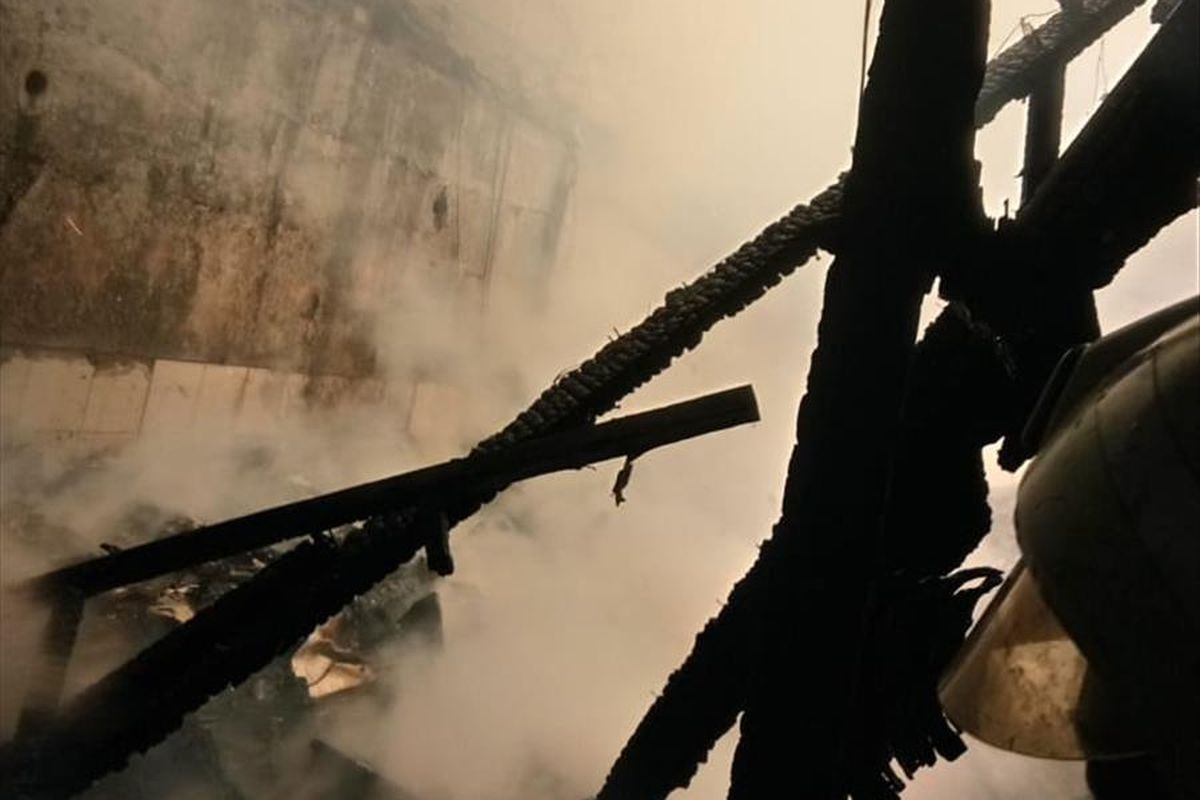 Kepulan asap saat petugas pemadam kebakaran berupaya menjinakkan api yang melalap rumah warga di Ciracas, Jakarta Timur, Selasa (18/6/2019).