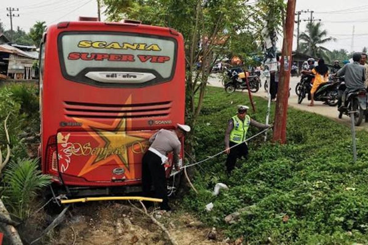 Polisi sedang memasang garis pengaman di lokasi kecelakaan bus Simpati Star di Desa Buket Pala, Kecamatan Idi Rayeuk, Aceh Timur, Minggu (30/10/2016)