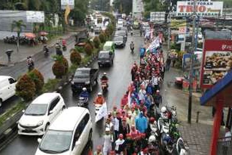 Massa dari sejumlah ormas islam di Bogor melintasi Jalan Raya Pajajaran melakukan long march menuju Jakarta untuk mengikuti aksi damai di Monas, Kamis (1/12/2016).