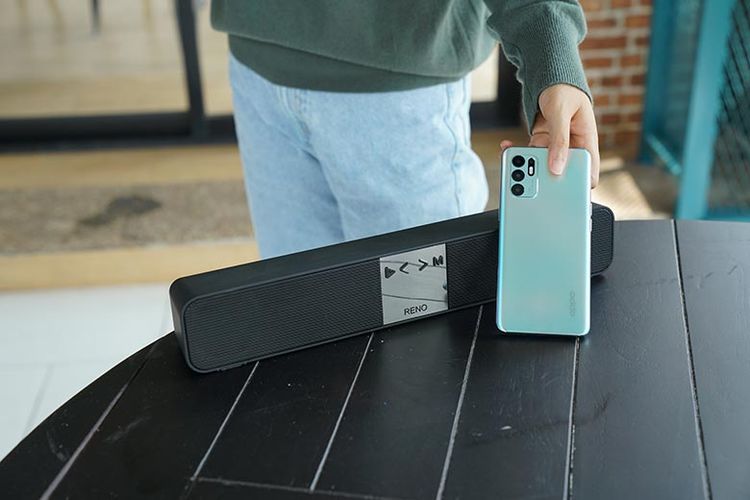 Ilustrasi penggunaan Oppo Reno6 yang dihubungkan dengan speaker wireless.