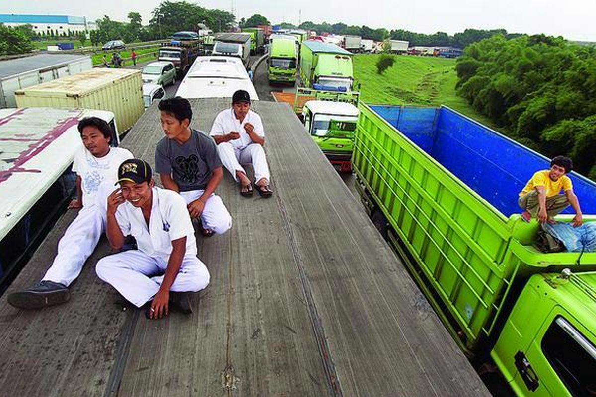 Sejumlah buruh menunggu rekannya yang berunjuk rasa dengan menutup Gerbang Tol Cibitung Selatan di kawasan industri MM2100, Cikarang Barat, Kabupaten Bekasi, Jawa Barat, Rabu (11/1). Kalangan buruh menuntut Apindo Kabupaten Bekasi mencabut gugatan atas upah minimum Kabupaten Bekasi 2012 dan membayarkan Rp 1,491 juta sesuai dengan keputusan  Gubernur Jawa Barat.