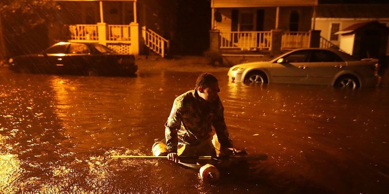 Seorang warga kota New Bern, Carolina Utara menaiki perahu darurat setelah air di Sungai Neuse yang meluap akibat badai Florence, Kamus (13/9/2018) malam. 