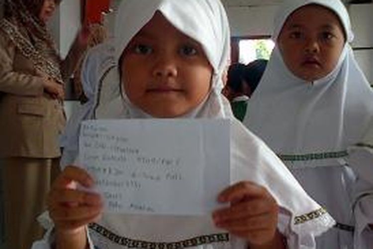  Faiha (5) siswa TK Perwanida, Ungaran ketika di Kantor Pos Ungran, Jl Diponegoro, Ungaran menunjukkan surat yang akan dikirimkan ke orangtuanya, Selasa (24/3/2015)