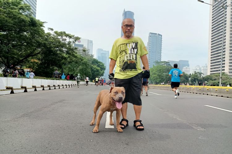 Ketua Forum Warga Kota Jakarta (Fakta) Azas Tigor Nainggolan bersama Alpen, anjing kesayangannya, saat berfoto di area car free day, Minggu (10/10/2022).