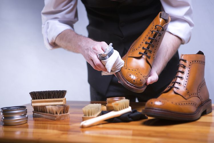Ilustrasi membersihkan sepatu boots kulit.