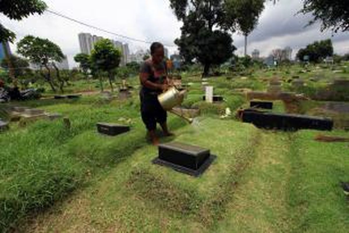 Pekerja tengah membersihkan area makam di TPU Karet Bivak, Tanah Abang, Jakarta Pusat, Senin (24/3/2014). Gaji puluhan petugas pengurus makam di Dinas Pertamanan dan Pemakaman DKI Jakarta, sejak Januari hingga Maret 2014 belum dibayarkan Pemprov DKI. Imbasnya, banyak pekerja non-pegawai negeri sipil (PNS) tersebut yang menunggak biaya sewa rumah hingga berhutang kepada rentenir. WARTA KOTA/ANGGA BHAGYA NUGRAHA