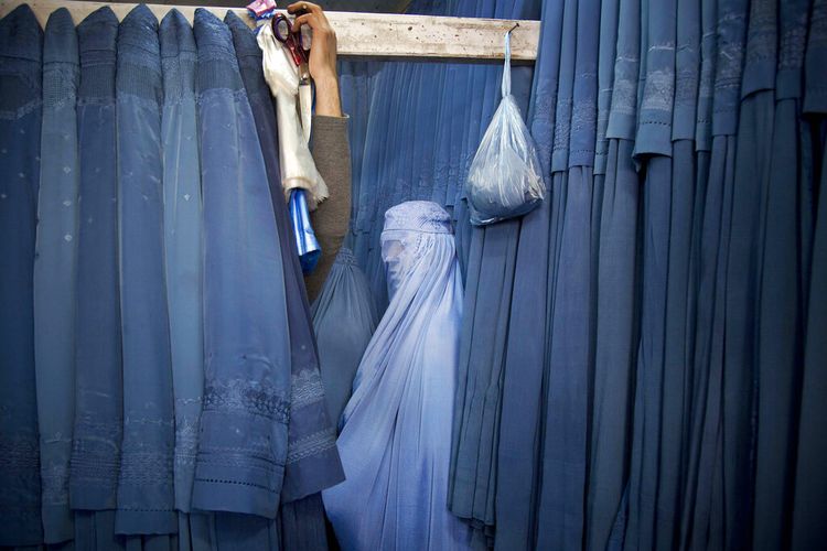 Dalam foto 2013 ini, wanita Afghanistan menunggu di ruang ganti untuk mencoba Burqa, pakaian ini wajib digunakan wanita di depan umum saat Taliban berkuasa. 