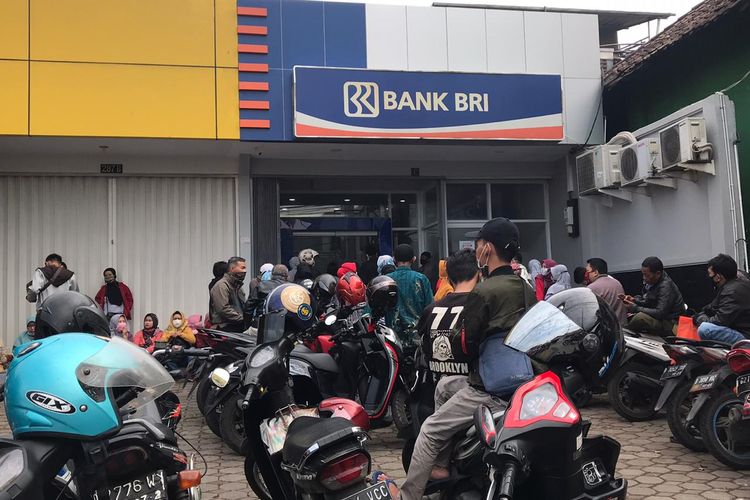 Puluhan pelaku UMKM mengantre di depan Bank BRI untuk mencairkan dana BLT UMKM sebesar Rp 2,4 juta. 