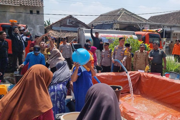 Pihak kepolisian membantu menyalurkan air bersih di salah satu desa yang terdampak kekeringan di Kecamatan Tikung, Lamongan, Jawa Timur, Senin (2/9/2024).