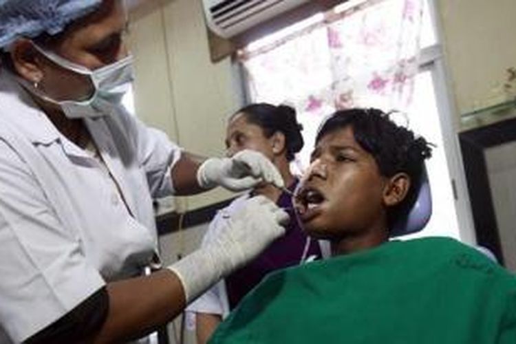 Dokter tengah memeriksa Ashik Gavai (17) setelah dia merasakan sakit selama bertahun-tahun akibat ratusan gigi kecil yang tumbuh di dalam mulutnya.