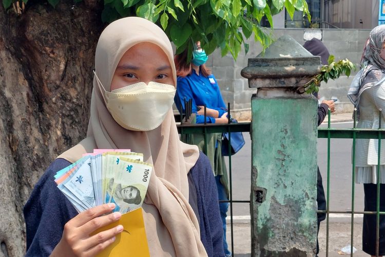 Erina (22) warga Jakarta Barat, rela mengantre panjang demi mendapatkan uang baru di layanan mobil keliling Bank Indonesia di Pasar Slipi, Palmerah, Jakarta Barat, Kamis (25/8/2022).