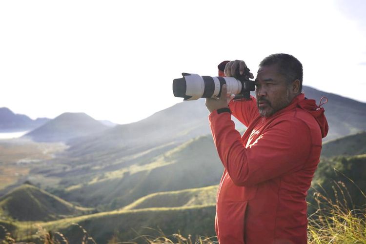 Fotografer Bunyamin Wari saat mengabadikan kameranya di suatu bukit dan pegunungan.