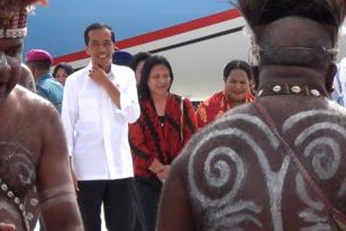 Presiden Joko Widodo bersama istri saat disambut dengan tarian adat di Bandara Sentani, Jayapura, Sabtu (27/12/2014). 