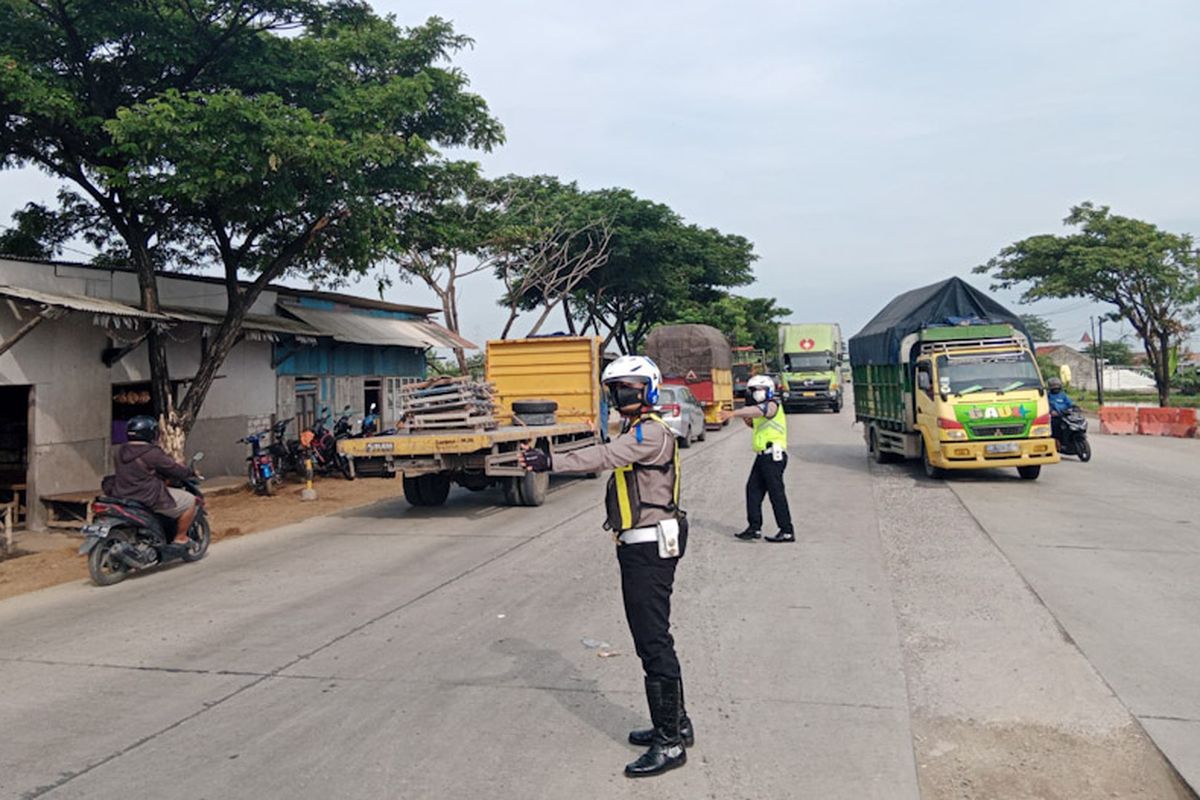 Petugas kepolisian saat mengatur arus lalu lintas di Jalur Pantura Gresik-Lamongan, Sabtu (12/3/2022).