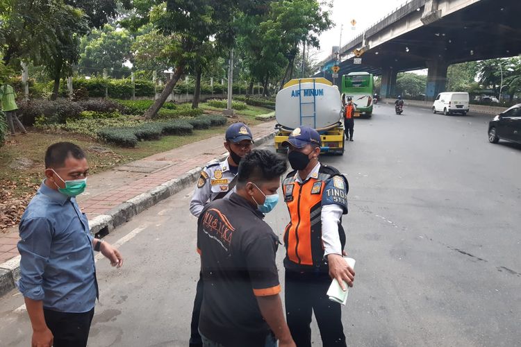 Petugas Dishub menghentikan bus yang mengangkut warga ke lokasi vaksinasi Covid-19, Selasa (7/9/2021). Ketua Forum Warga Kota Jakarta (Fakta) Azas Tigor Nainggolan menyebut, dua petugas itu memeras supir bus dengan meminta uang Rp 500.000.