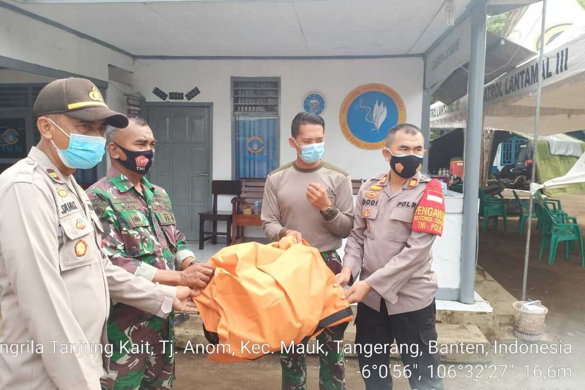 Petugas Polsek Pakuhaji, Kabupaten Tangerang mengevakuasi potongan tubuh yang diduga penumpang pesawat Sriwijaya Air SJ 182 yang ditemukan di sekitar Pantai Kis, Selasa (19/1/2021)