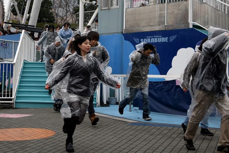 Pengunjung taman bermain di Tokyo berpartisipasi dalam kegiatan latihan evakuasi simulasi darurat serangan misil balistik yang digelar Januari lalu.