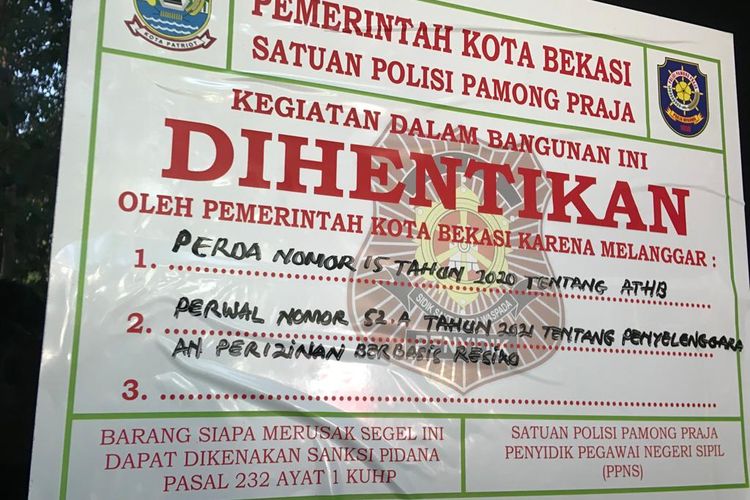 Stiker pemberhetian segala aktivitas yang ditempel oleh pihak Satpol PP Kota Bekasi tepat di pintu masuk Holywings Bekasi, Rabu (29/6/2022). Penghentian aktivitas tersebut dilakukan usai pihak Satpol PP menemukan adanya dua pelanggaran yang dilakukan oleh manajemen Holywings Bekasi. 