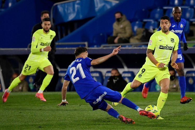 Luis Suarez (kanan) mendapat adangan dari Sofian Chakla dalam pertandingan Getafe vs Atletico Madrid pada pekan ke-27 kompetisi teratas Liga Spanyol, La Liga, musim 2020-2021 yang digelar di Stadion Coliseum Alfonso Perez, Sabtu (13/3/2021) malam waktu setempat. (Foto oleh PIERRE-PHILIPPE MARCOU / AFP)