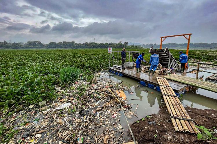 Aktivitas pengangkatan sampah plastik dari sungai Citarum menggunakan teknologi trash boom dan konveyor apung di Bandung Barat.