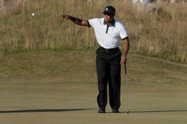 Pegolf Amerika Serikat, Tiger Woods,  bersiap menangkap bola yang dilemparkan oleh caddie Joe LaCaya, pada hari pertama The Open Championship di Muirfield, Skotlandia, Kamis (18/7/2013).