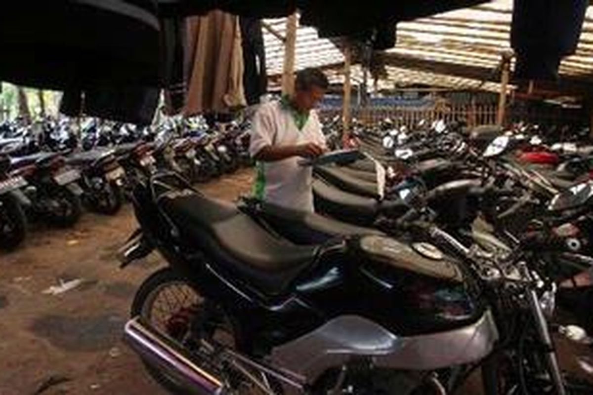 Wowo, mencatat motor yang parkir sebelum ia berganti shift kerja di parkir motor 24 jam di kawasan Cawang, Jakarta, Selasa (8/3/2011). Mulai dari UKI hingga Cawang terdapat sekitar 9 jasa parkir motor 24 jam yang masing-masing menampung sekitar 100-400 motor.Jasa parkir ini rata-rata dipenuhi motor para komuter yang bekerja di Bandara dan pabrik-pabrik di Cikarang yang dijemput bus atau mobil perusahaan yang menjemput di kawasan itu. Biaya parkir Rp 3.000 per 12 jam atau Rp 45.000 hingga 50.000 per bulan.