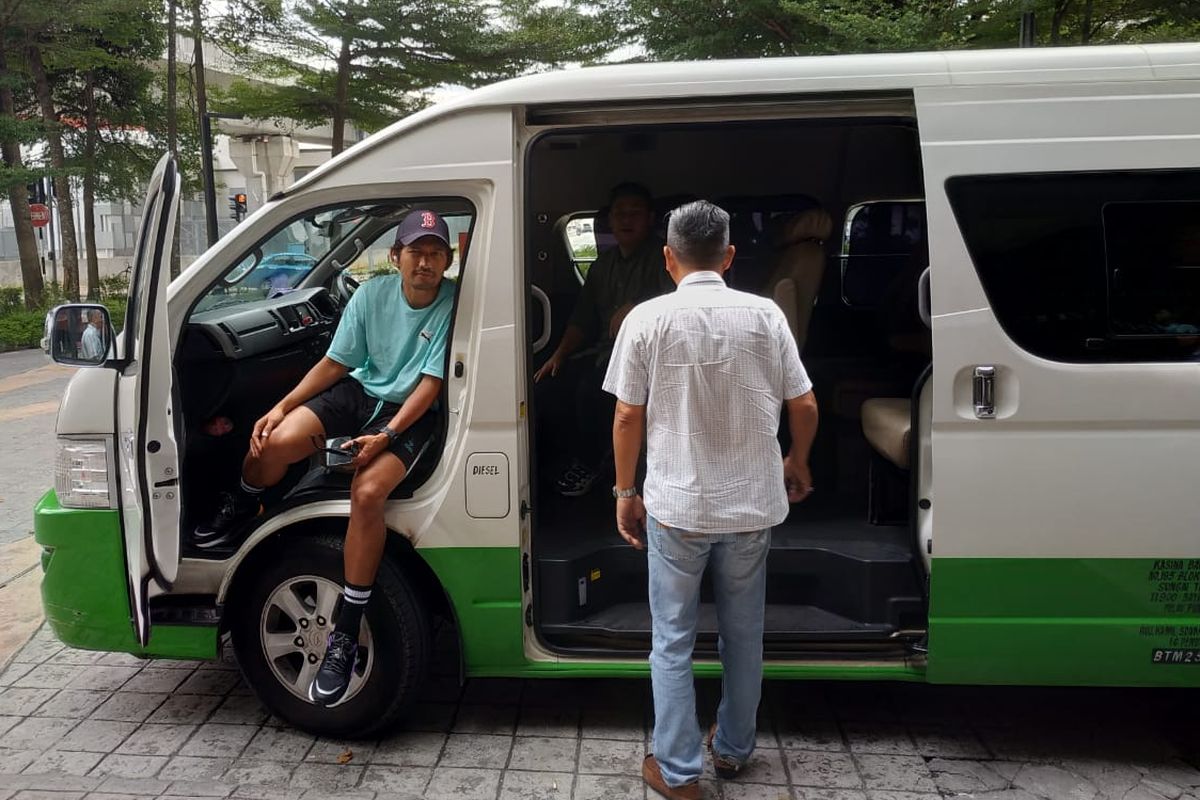 Ibnu Jamil (kiri) duduk di kursi depan dalam bus kecil yang membawa rombongan Puma Indonesia selama berada di Subang Jaya, Malaysia. 