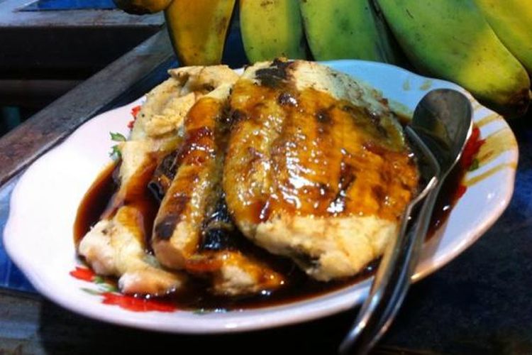 Menyantap seporsi kuliner pisang epe dengan baluran saus gula merah rasa durian di pinggir Anjungan Pantai Losari, Rabu, (11/02/2015).