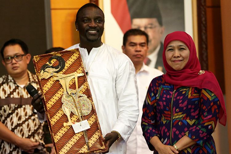 Penyayi rap, Aliaune Damala Akon Thiam alias Akon menunjukkan cinderamata dari Menteri Sosial Khofifah Indar Parawansa saat mini konser Akon di Kementerian Sosial dalam rangka program Akon Terangi Suku Anak Dalam, Orang Rimba, dan Komunitas Adat Terpencil, Rabu (8/3/2017). Program donasi tersebut mencangkup instalasi peralatan pembangkit listrik tenaga matahari di tiap rumah dan mempromosikan penghematan energi.