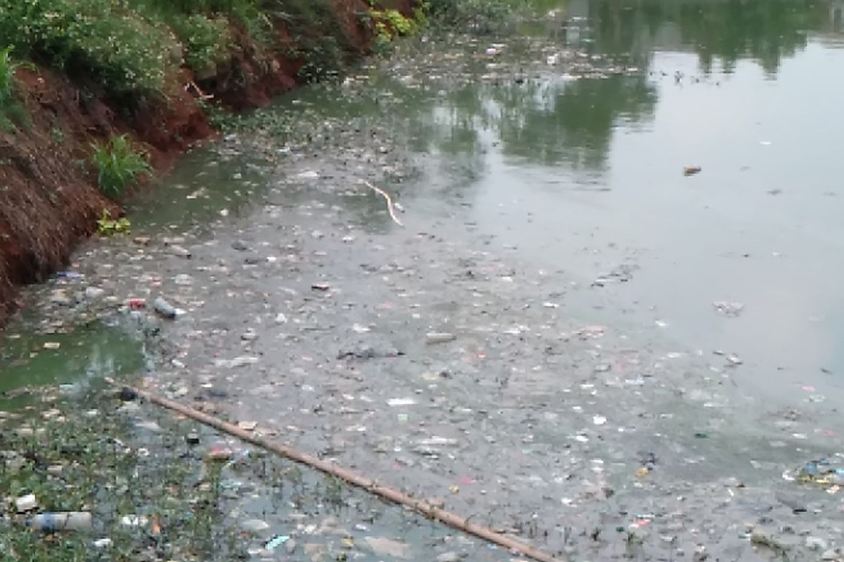 Sampah plastik dan dedaunan memenuhi permukaan waduk Jagakarsa, Jakarta Selatan, Rabu (18/12/2019)