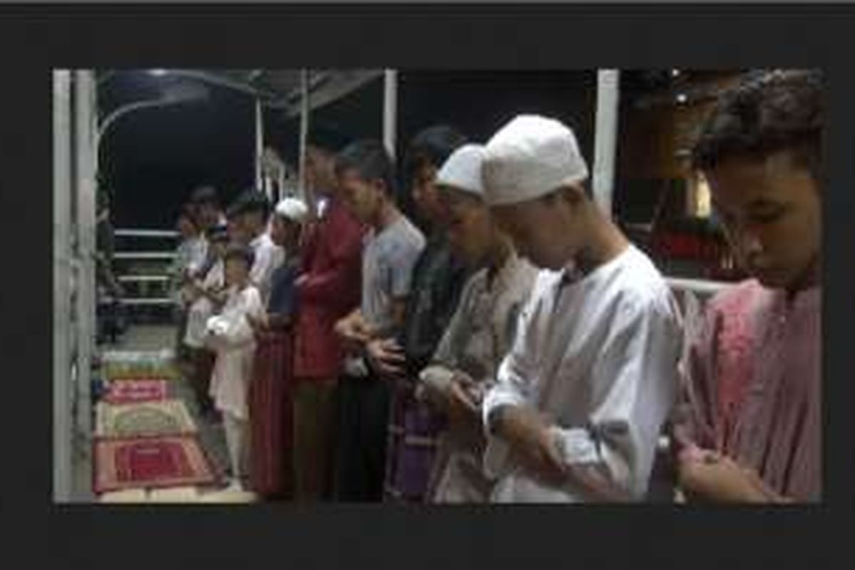 Warga jalankan salat tarawih di Jembatan Penyeberangan Orang (JPO) Pasar gembrong, Jakarta Timur, Minggu (5/6/2016) 