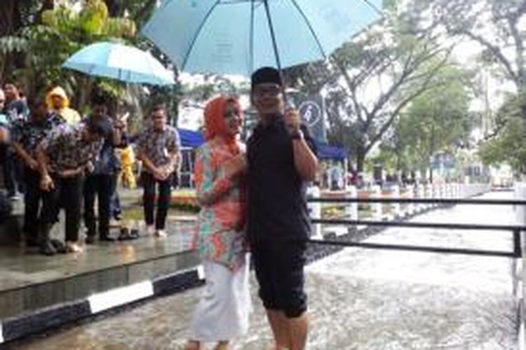 Wali Kota Bandung Ridwan Kamil saat bermain air di sugai Cikapayang bersama istrinya Atalia Kamil, Kamis (31/12/2015)
