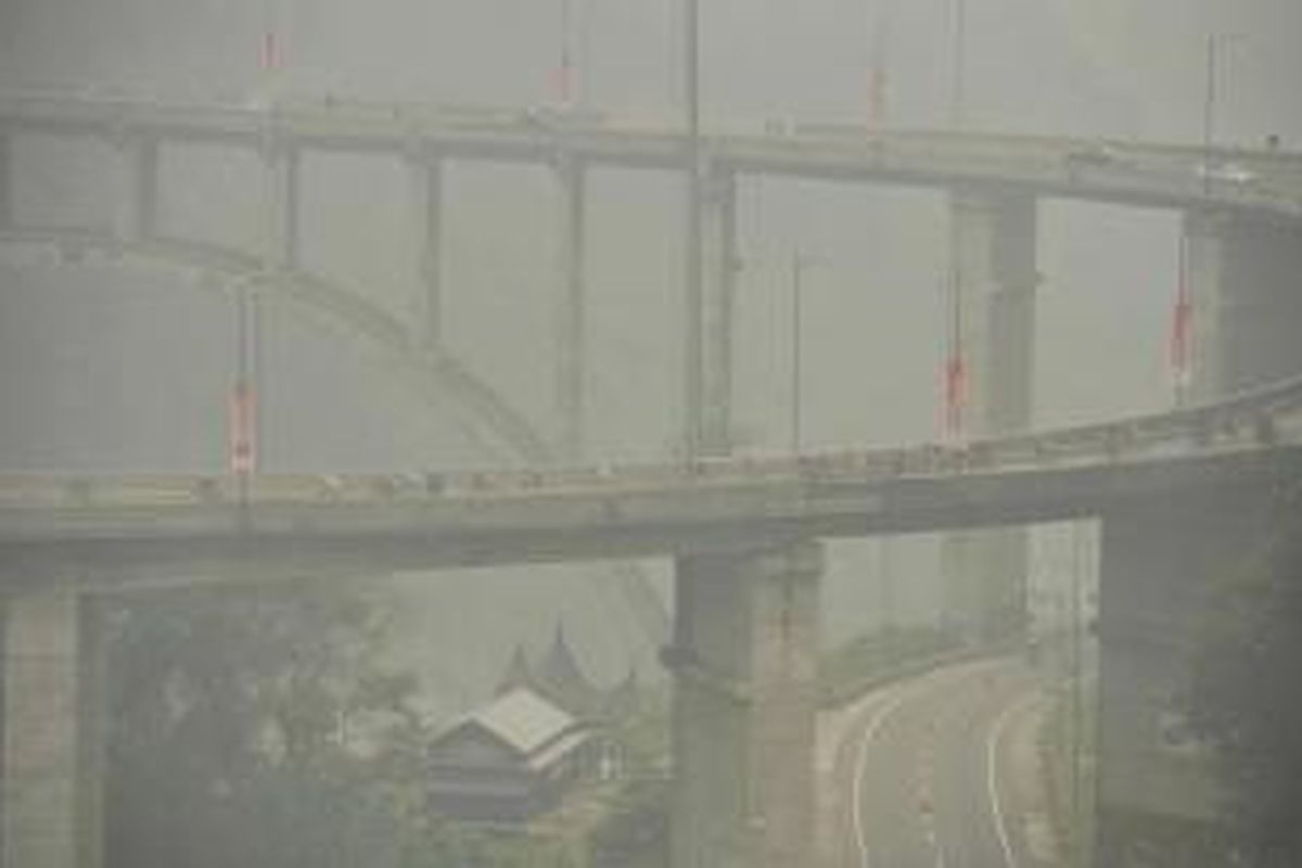 Para pebalap menembus kabut asap saat melintas di Jembatan Kelok Sembilan, Kabupaten Lima Puluh Kota, Sumatera Barat, dalam etape kelima Tour de Singkarak, Rabu (7/10/2015).