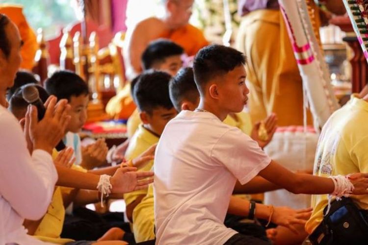 Beberapa dari 12 remaja laki-laki di Thailand yang diselamatkan dari dalam goa Tham Luang menghadiri upacara keagamaan di sebuah kuil Buddha di Chiang Rai pada Kamis (19/7/2018). (AFP/Krit Phromsakla Na Sakolnakorn)