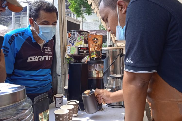 Barista Kedai Secangkir Insipirasi Kopi menyajikan kopi di gelaran Hari Kopi Internasional di Lapangan Enggal, Lampung, Sabtu (2/10/2021).