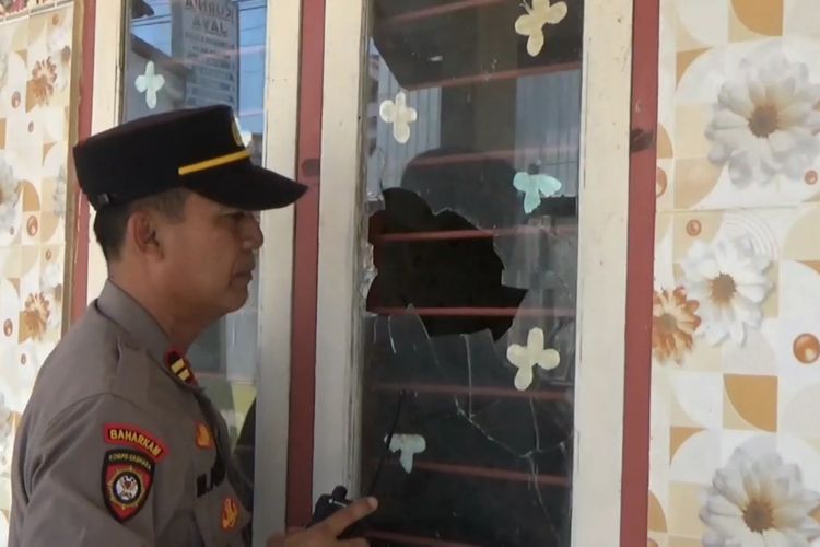 Polisi menunjukkan kaca pecah di salah satu fasilitas umum akibat lembaran batu dari dua kelompak perguruan pencak silat yang bentrok, di Kabupaten Tulungagung Jawa Timur, Sabtu (13/01/2024).